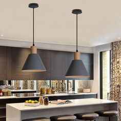 a kitchen with three pendant lights hanging from the ceiling