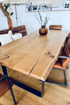 a wooden table with leather chairs around it