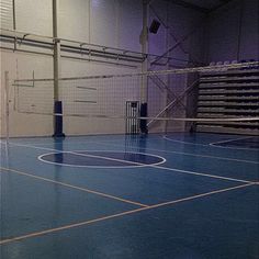 an indoor basketball court with blue floors and net