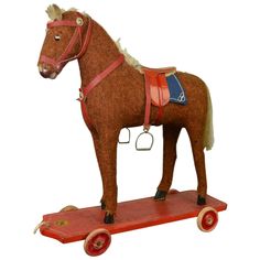 a toy horse is standing on top of a red skateboard and wearing a harness