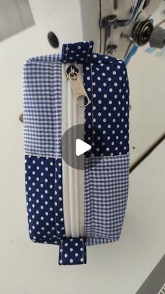 a sewing machine with blue and white polka dot fabric on it's side, next to a zipper