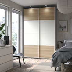 a bedroom with a bed, dresser and sliding closet doors in the middle of it