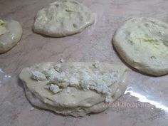 four uncooked cookies sitting on top of a cookie sheet