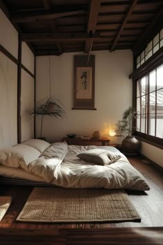 a bed with white sheets and pillows in a room