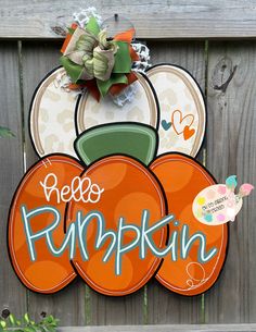 there is a sign that says hello pumpkin on the side of a wooden fence with plates