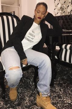 a woman sitting in a chair with ripped jeans