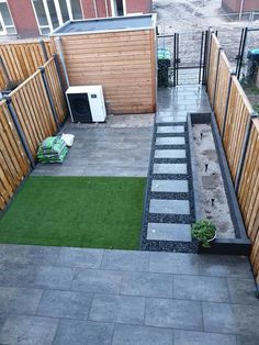 a small backyard with grass and wooden fence