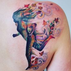 a woman's back with a colorful tattoo on her shoulder and the image of a mermaid