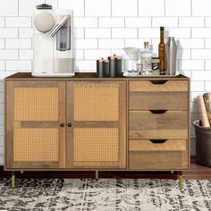 a wooden cabinet sitting on top of a rug next to a coffee maker and other items