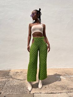 a woman wearing green pants and a crop top