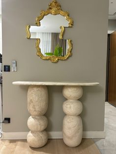 a table with two large rocks underneath it and a mirror on the wall behind it