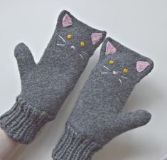 two gray cats mittens sitting on top of a white table