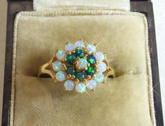 This exquisite ring boasts a stunning combination of fine silver, gold, cultured white Opal and dark blue Opal, stones. It features a Victorian Cluster style design that exudes elegance and luxury. The ring is crafted with 925 metal purity with an 18ct gold finish making it a valuable addition to any fine jewellery collection. The ring is available in size O.1/2 and is perfect for any occasion. Whether you're looking for a gift for a loved one or simply treating yourself, Ring box in photos just Exquisite Cluster Rings For Gift, Elegant Multi-stone Cluster Opal Ring, Cluster Multi-stone Jewelry Gift, Cluster Multi-stone Jewelry For Gifts, Unique Cluster Jewelry As Gift, Exquisite Multi-stone Cluster Ring Gift, Elegant Cluster Ring With Cabochon As A Gift, White Cluster Jewelry For Gifts, White Cluster Jewelry As A Gift