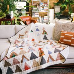 a living room filled with furniture and lots of plants