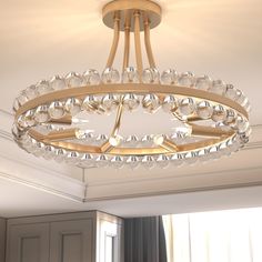 a chandelier hanging from the ceiling in a room with white walls and windows