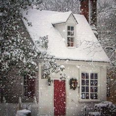 a white house with a red door in the snow