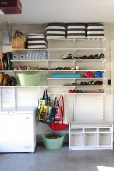 a room filled with lots of shelves and bins next to a white freezer