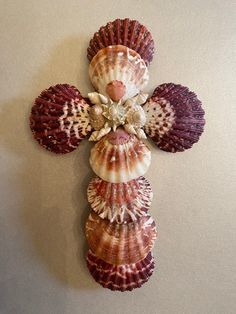 a cross made out of seashells on a wall