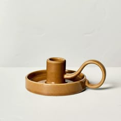 a brown cup and saucer sitting on top of a white table next to each other