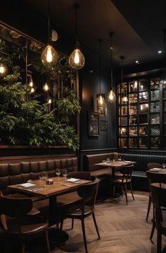 an empty restaurant with wooden tables and leather booths, hanging lights and plants on the wall