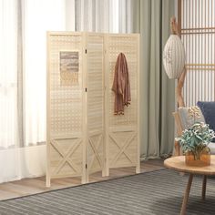 a room divider in front of a window with curtains