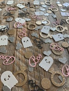 a wooden table topped with lots of cut outs and glitters on top of it