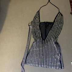 a black and white striped top hanging on a wall next to a tie with sequins