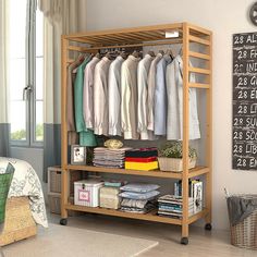 an organized closet with clothes hanging on the rack and other items in baskets next to it