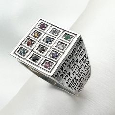 Embark on a spiritual journey with our Men's Hoshen Ring, meticulously handcrafted in Sterling Silver (925) and enriched with the divine presence of the 72 Names of God, accompanied by 12 Genuine Hoshen Stones. 🌟✨ Exploring the Meaning Behind Each Stone: 1.Jasper (Odem): Represents the tribe of Reuben, symbolizing stability and grounding energy. 🏞️ 2.Sapphire (Pitdah): Linked to the tribe of Simeon, symbolizing sincerity and inner peace. 🌀 3.Agate (Bareket): Associated with the tribe of Levi, Spiritual Multi-stone Rings For Gift, Spiritual 925 Sterling Silver Gemstones, Spiritual Sterling Silver Multi-stone Rings, Silver Multi-stone Spiritual Rings, Spiritual Multi-stone Sterling Silver Rings, Artisan Sterling Silver Rings For Ceremonial Occasions, Spiritual Sterling Silver Gemstones With Accent Stones, Multicolor Sterling Silver Spiritual Rings, Ceremonial Artisan Sterling Silver Rings