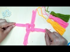 someone is making a cross out of yarn