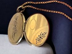 "Description: Beautiful oval vintage 12K gold filled locket features an etched floral and pinstriped design on the front that features flowers, leaves, a curve, and an oval cartouche. The cartouche is at the top left of the oval shaped locket and has some etched vertical columns of lines around it. The bottom right features an etched floral design that is filled with Niello, or a dark enamel to make it stand out. There is a curved double etched line that separates the flower from the other etche Locket Necklace Vintage, Gold Locket Necklace, Retro Era, Round Locket, Oval Locket, Vintage Lockets, Photo Pendant, Gold Locket, Round Necklace