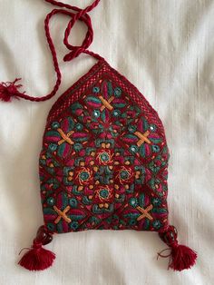 Embroidered and Mirrored Rabari Small Coin Purse, Card Holder, Jewelry Case with Cotton batik print lining, string wrap closure. Bead and tassel trim. Rayon Embroidery on Cotton. These are beautiful embroidered treasures to put your jewels in! Handmade in India by various Rabari tribal villages to encourage and maintain traditional craft that has been part of tribal life for hundreds of years. Case measures 2" high x 3.75" wide, wrap top over case and tie at top. Handmade in India Traditional Embroidered Clutch For Festivals, Traditional Multicolor Embroidered Pouch Clutch, Traditional Clutch With Multicolor Embroidery As Gift, Traditional Multicolor Embroidered Clutch As Gift, Traditional Embroidered Red Clutch, Traditional Red Embroidered Clutch, Handmade Traditional Pouch For Festivals, Traditional Handmade Pouch For Festivals, Traditional Red Pouch Clutch