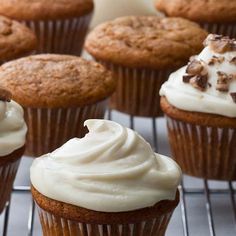 several cupcakes with frosting and chocolate chips on top sitting on a cooling rack