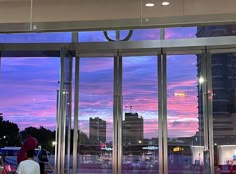 people are standing in front of large glass doors