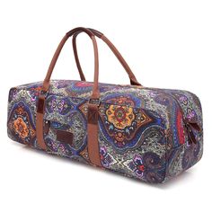 a colorful paisley print duffel bag with brown leather handles and two zippered compartments