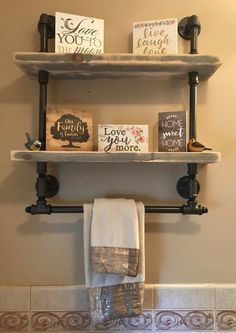 two shelves with books on them above a toilet in a bathroom, next to a towel rack