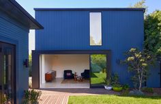 a blue house with an open patio and sliding glass doors that lead into the back yard