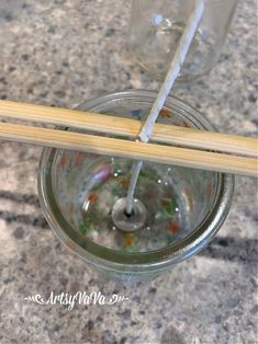 chopsticks sticking out of a glass filled with water