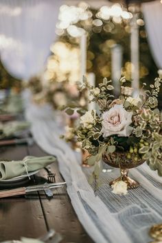 the table is set with silverware and flowers