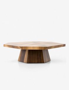 a round wooden table sitting on top of a white floor