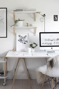 a white desk with two computer monitors on top of it and shelves above the desk