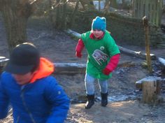 two young boys are playing in the woods