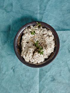 a bowl filled with food sitting on top of a blue cloth covered table next to a knife