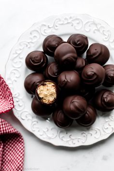 chocolates on a white plate with a red and white checkered napkin next to it