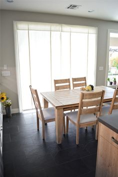 a dining room table and chairs in front of a sliding glass door