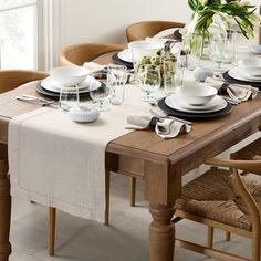 a dining room table set with place settings