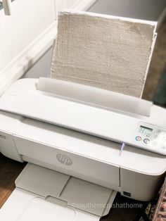 a white printer sitting on top of a wooden table