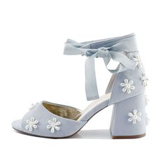 a pair of blue shoes with white flowers on the heel and ribbon tied around the ankle