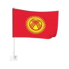 a red and yellow flag with the sun on it's side, flying in the wind