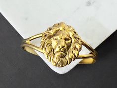 Gold Lion's Mane Cuff Bracelet...  I attached a matte gold plated lion's head brass stamping to the top of a gold metal cuff bracelet.  The cuff is adjustable. This would be a great gift for men and women! This cuff will fit medium to large wrists.  You will receive this fabulous lion's head cuff gift wrapped!  A perfect gift for someone with a Leo birthday! Nature inspired necklaces are listed here! https://www.etsy.com/shop/DaysLongGone?section_id=6063593 LION lockets listed in this section! h Lannister Fashion, Lion Oc, Birthday Nature, Lion Head Bracelet, Gold Arm Cuff, House Lannister, Lion Bracelet, Lion Gifts, Lion Jewelry